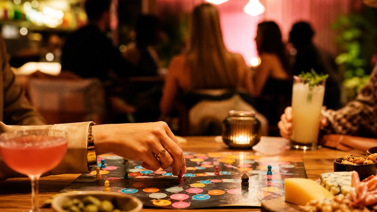 Hands playing a colorful board game on a cafe table with drinks in Las Vegas
