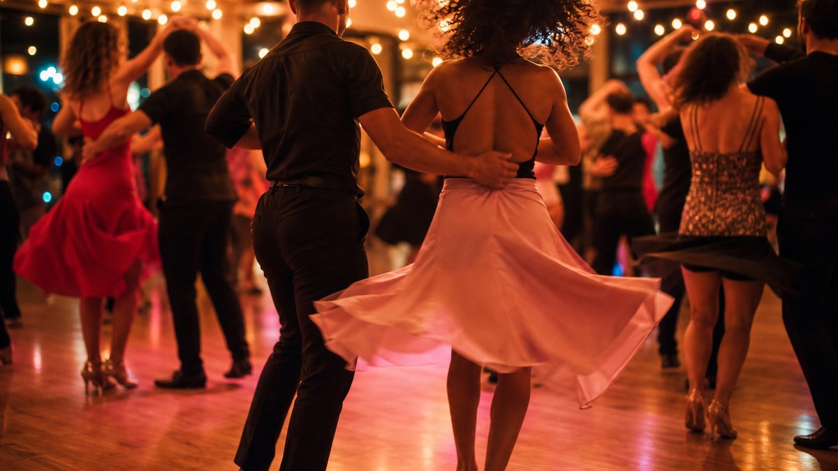 Couples dancing salsa at a warmly lit Las Vegas dance social